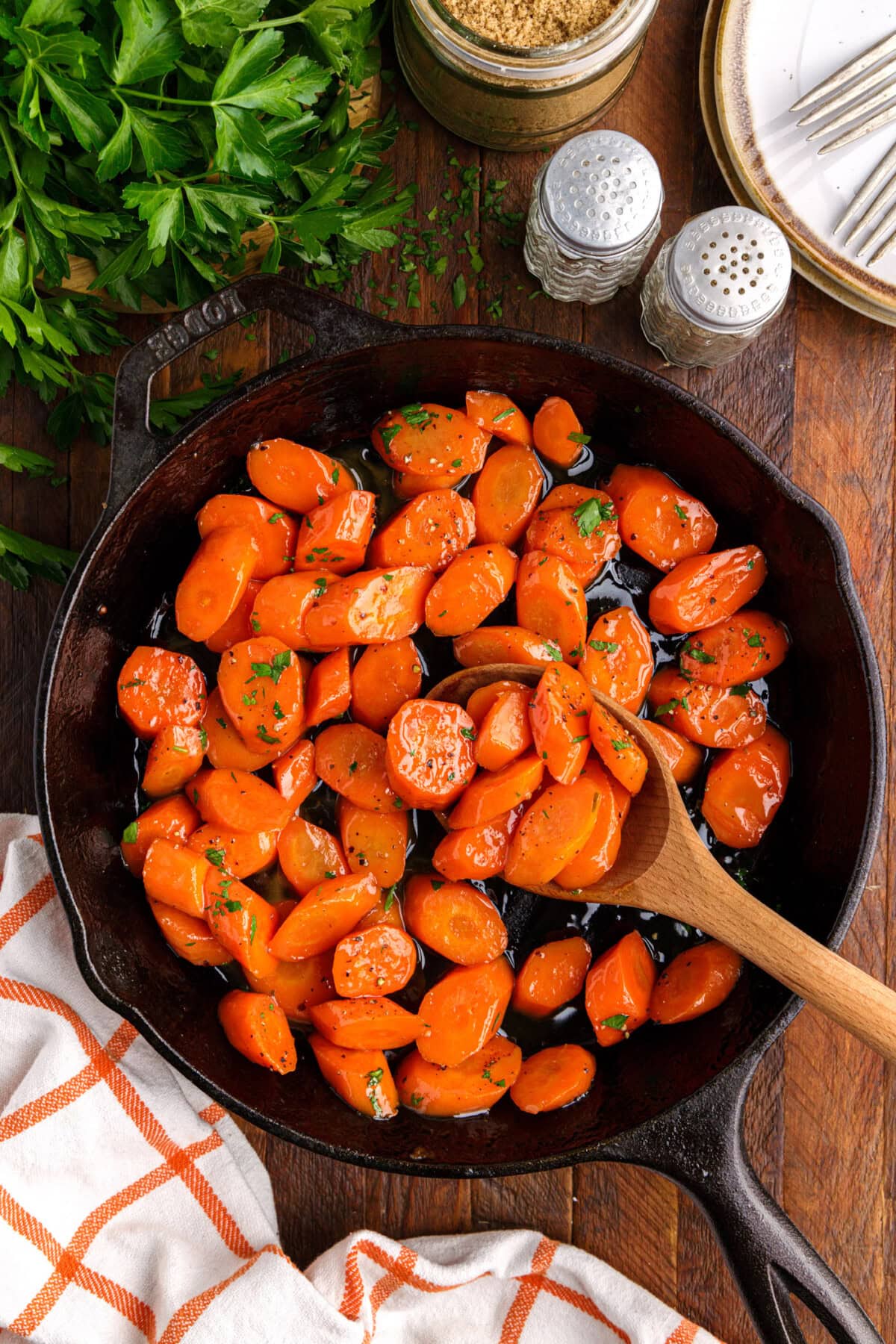 wooden spoon in skillet of Glazed Carrots