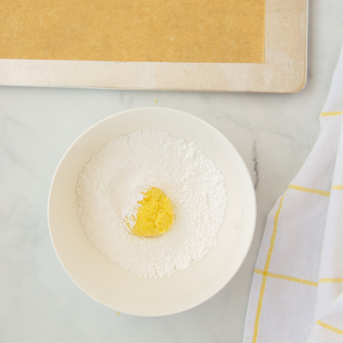 rolling lemon cookies in powdered sugar