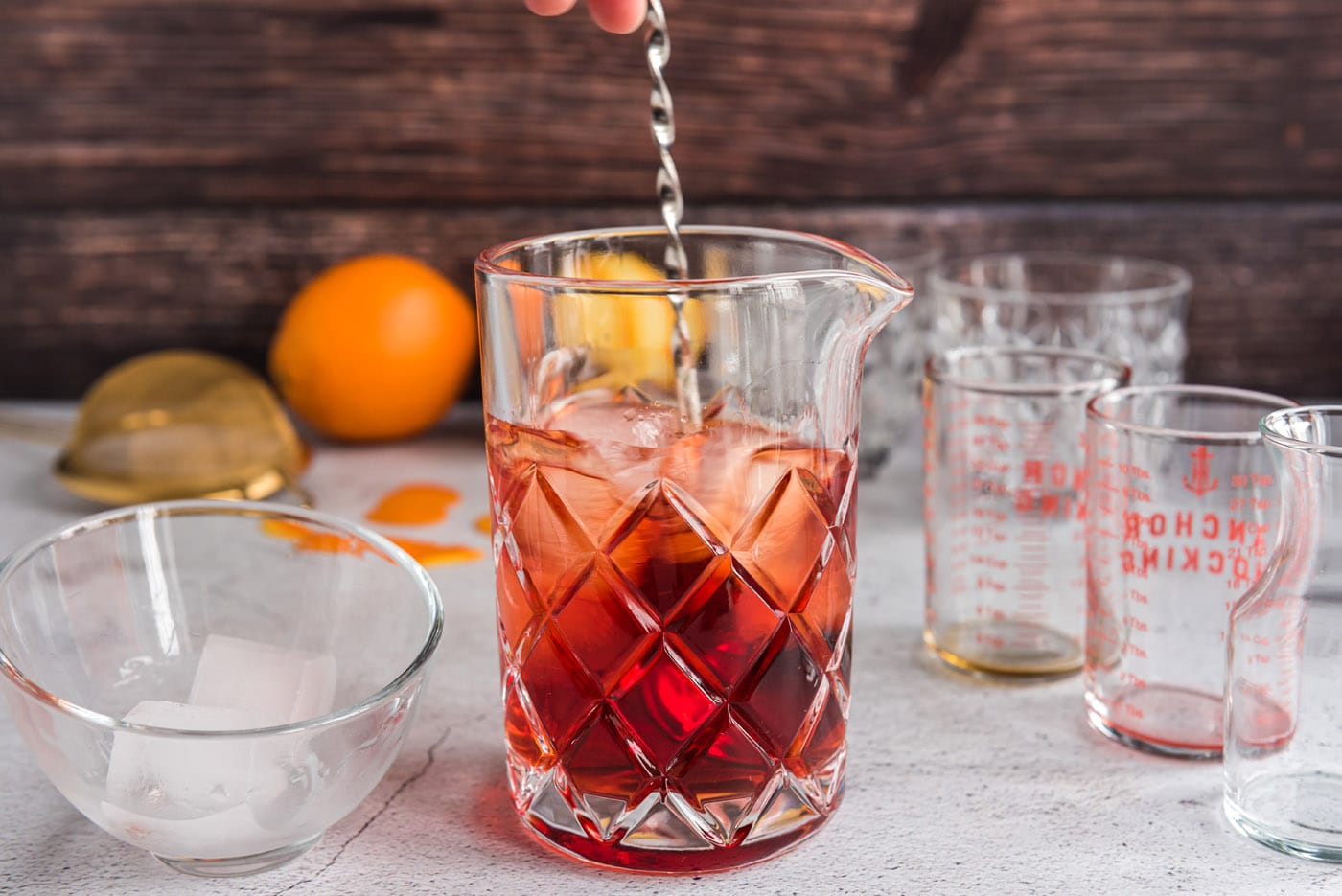 pouring ingredients for Negroni into a mixing glass