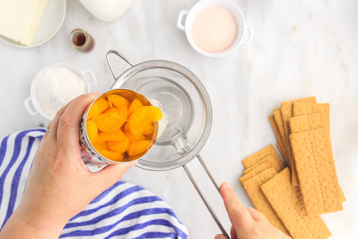 draining mandarin oranges into measuring cup
