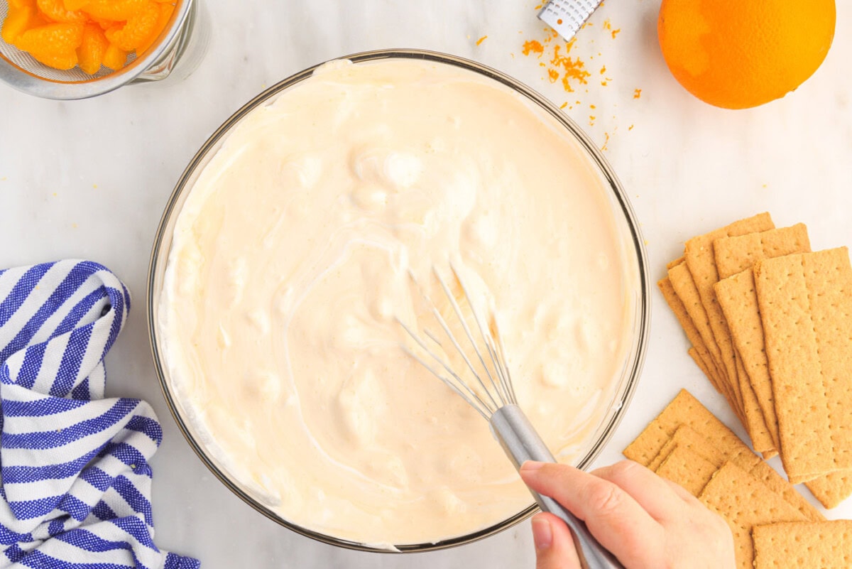 whisking orange icebox cake mixture in a bowl