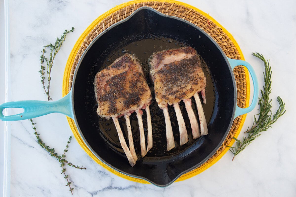 rack of lamb searing in skillet