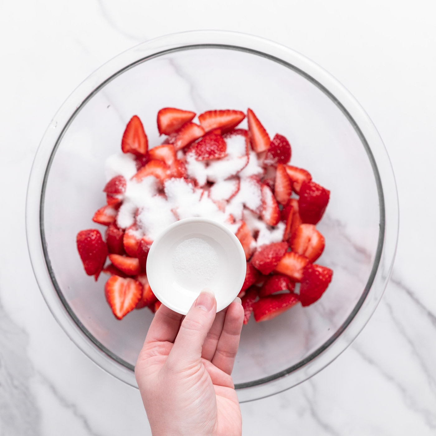 sprinkled sugar on top of chopped strawberries