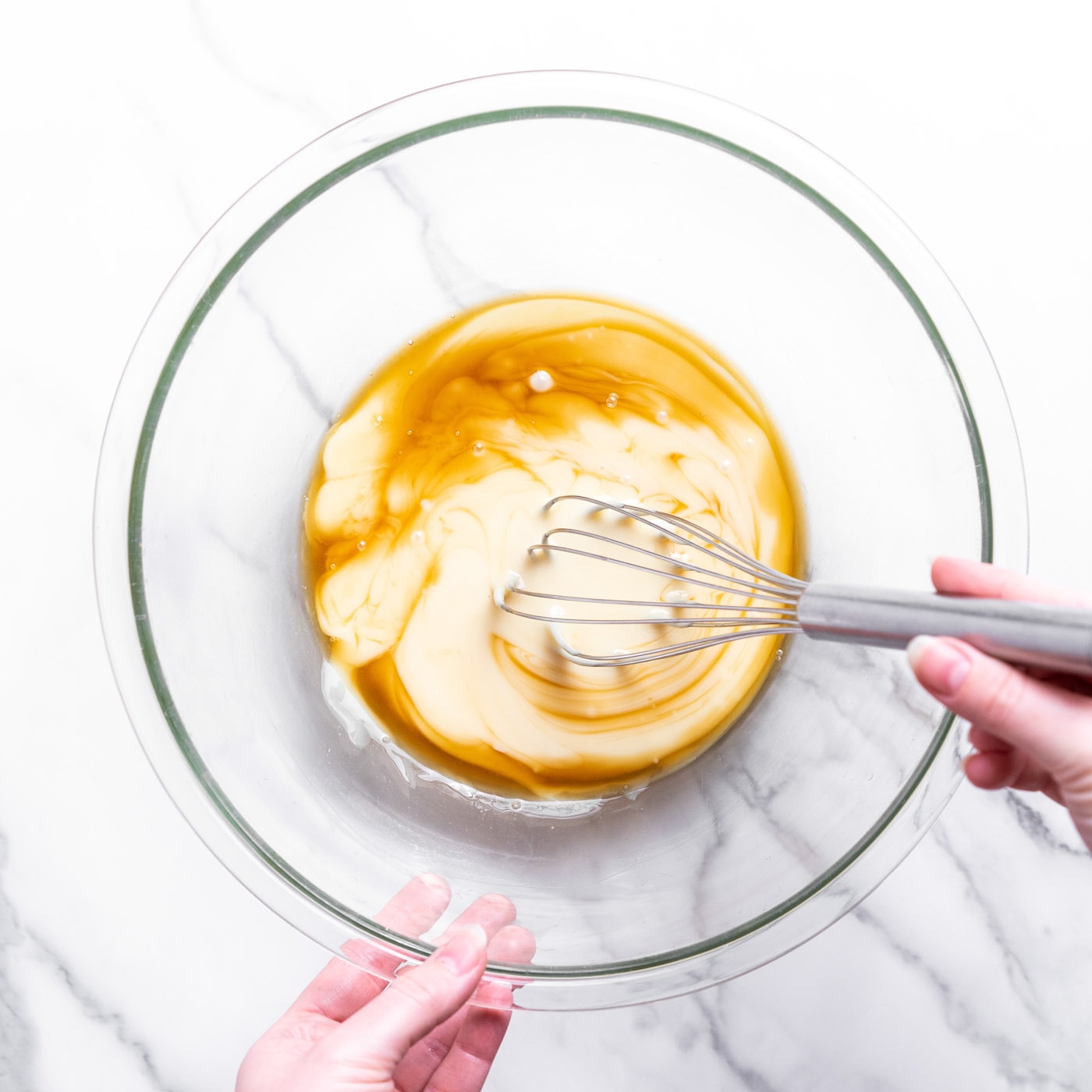 whisking sweetened condensed milk with vanilla in a bowl