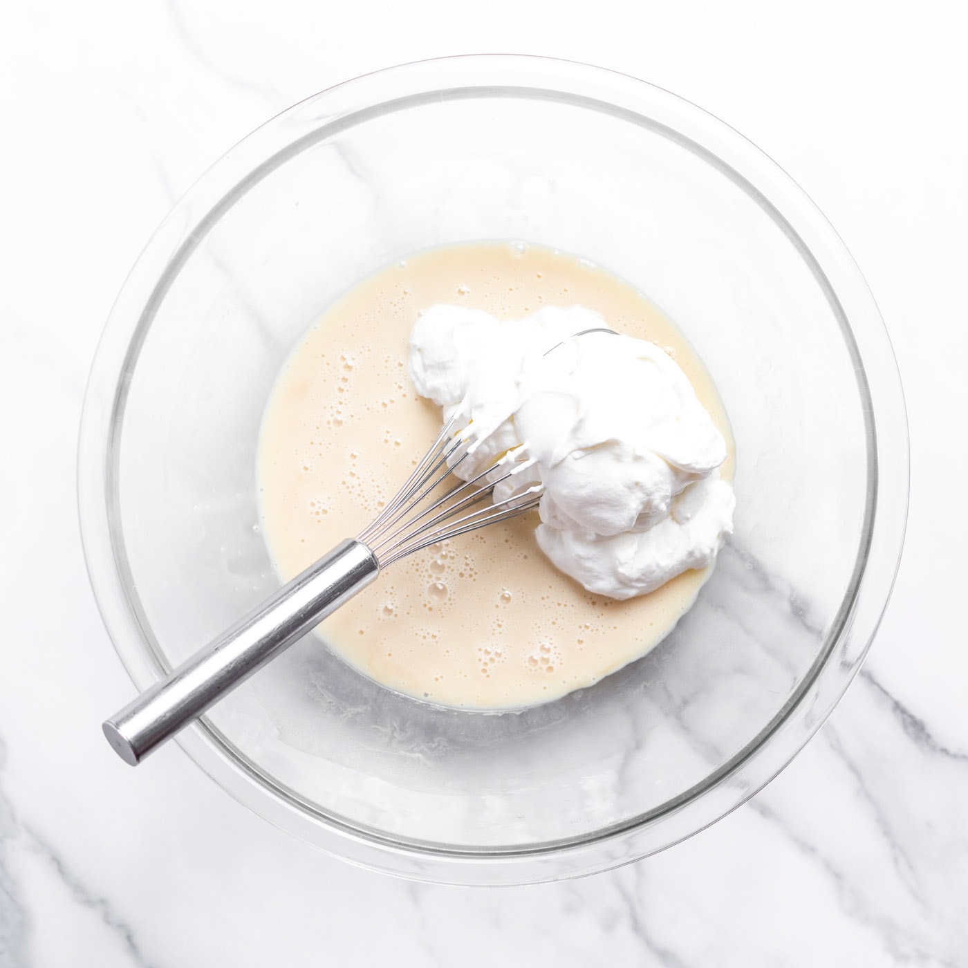whisking together sweetened condensed milk and whipped cream