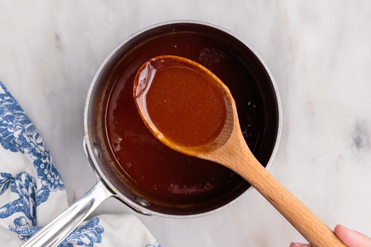 wooden spoon holding caramel sauce