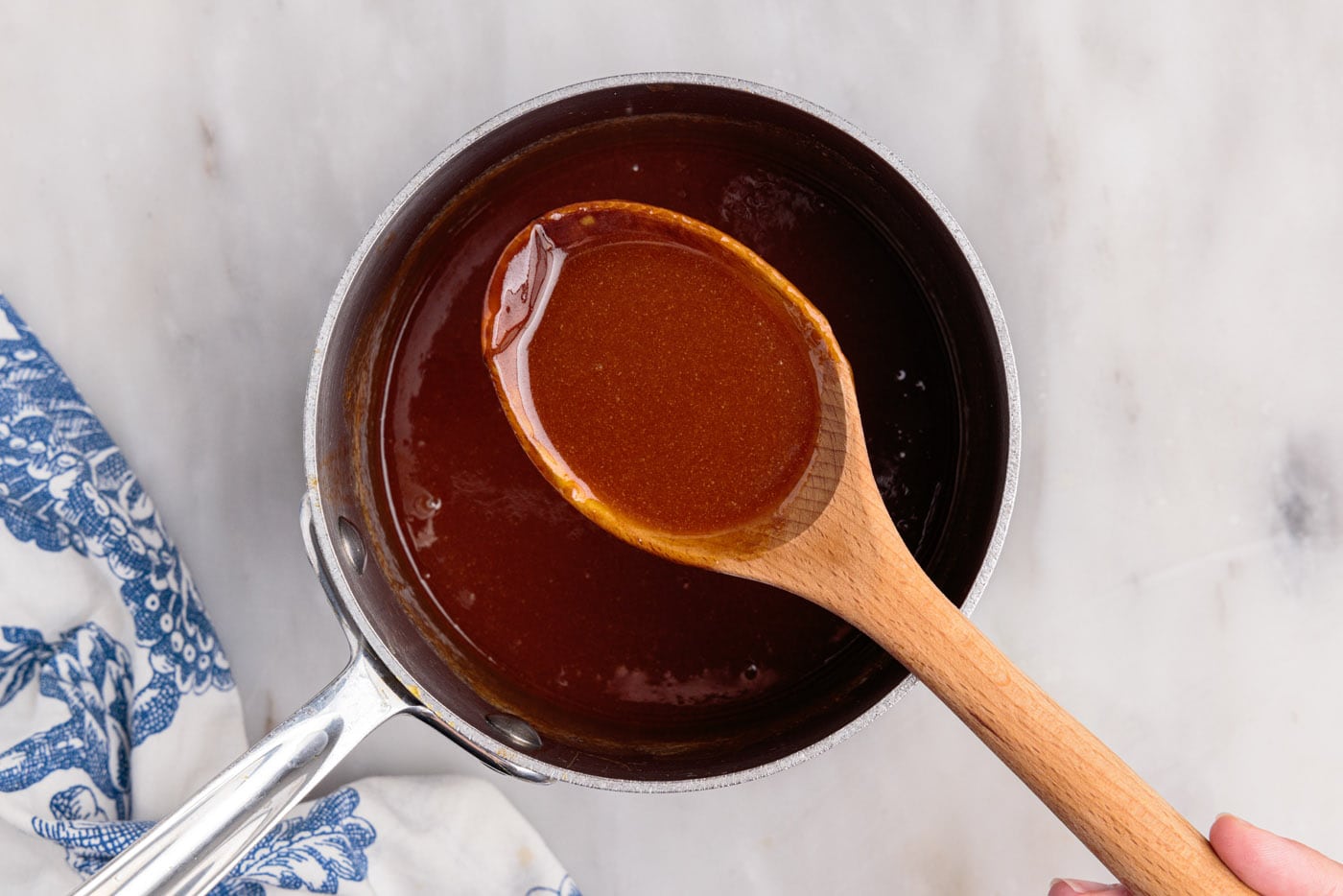 wooden spoon holding caramel sauce