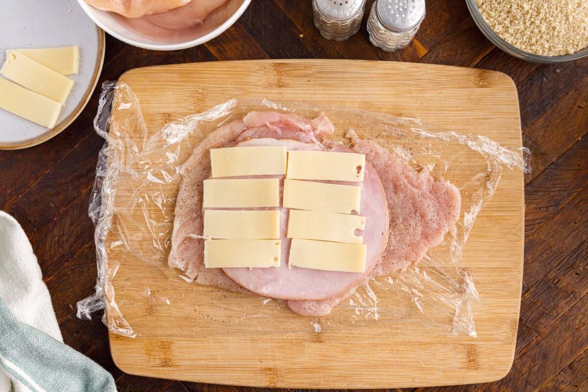 swiss cheese and ham on top of chicken breast