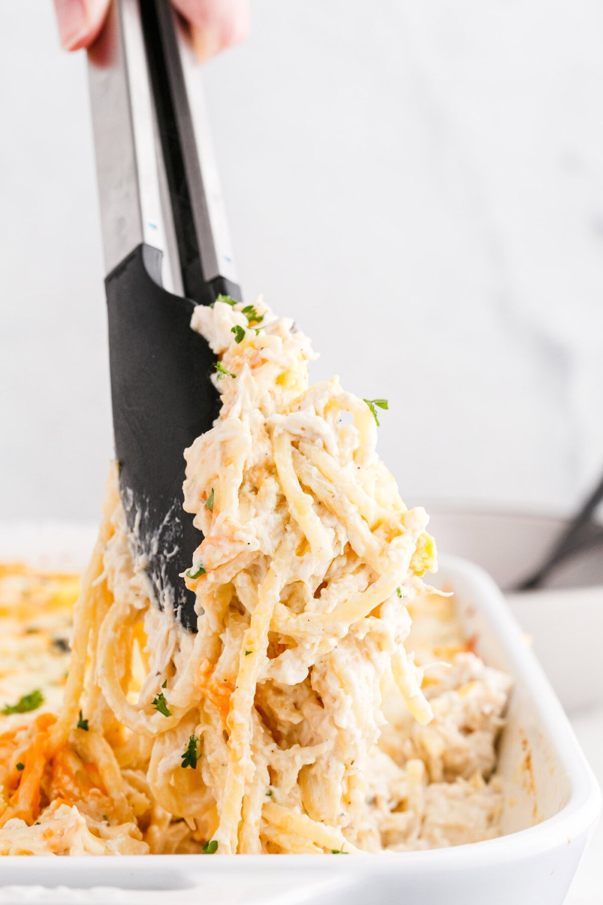 tongs lifting Chicken Tetrazzini