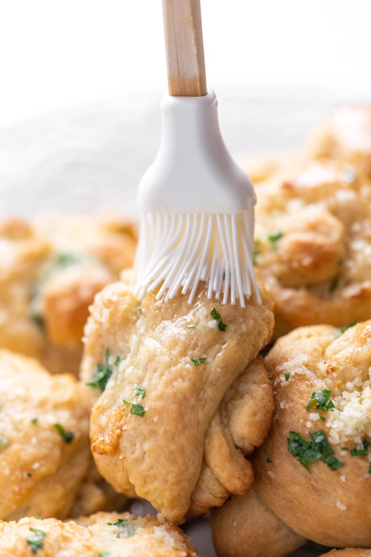 brushing butter on garlic knots