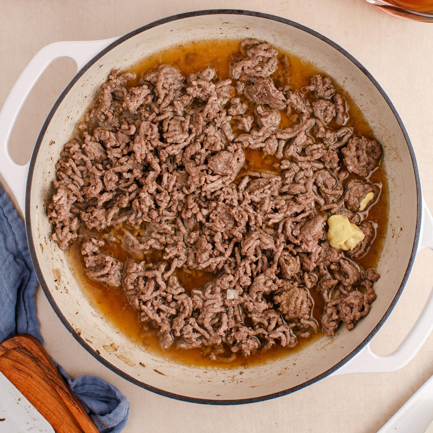 Dijon, worcestershire, beef broth and ground beef in a skillet