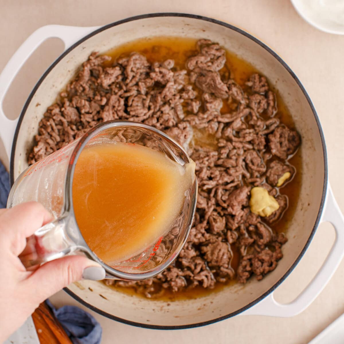 adding beef broth and flour mixture to ground beef