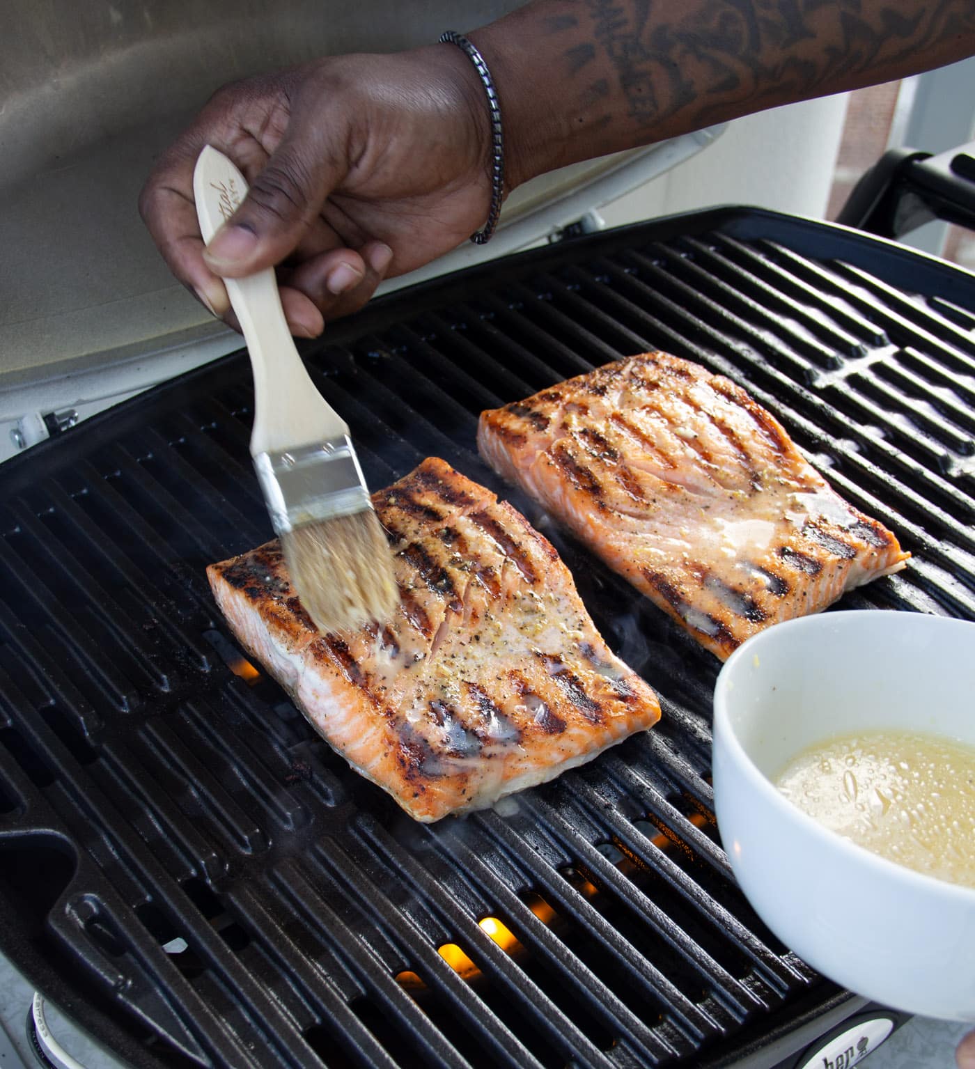 brushing marinade over salmon filets on grill