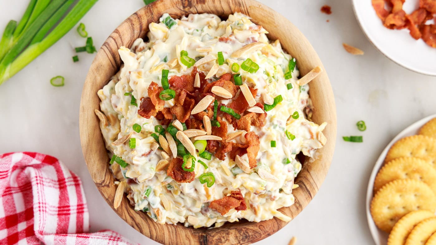 This party dip is packed with a creamy mayo base, savory crumbled bacon, toasted slivered almonds, a