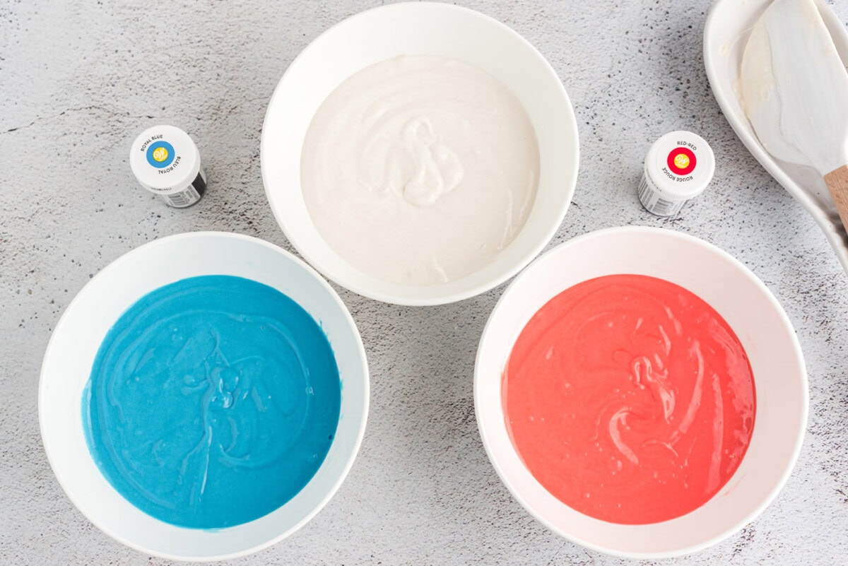 colored cake batter in bowls