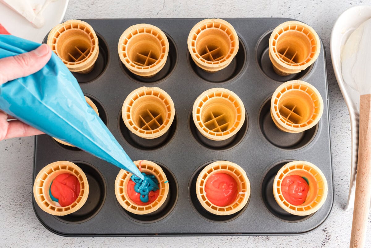 piping blue cake batter inside an ice cream cone