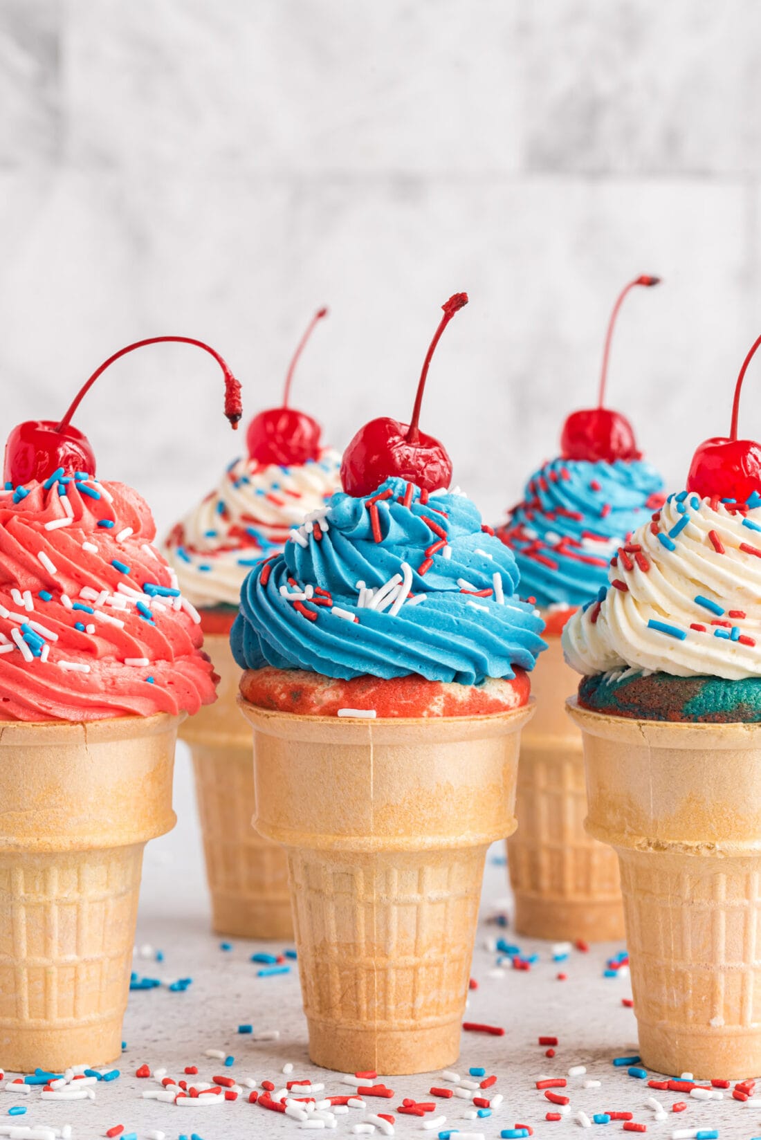 Patriotic Ice Cream Cone Cupcakes topped with cherries