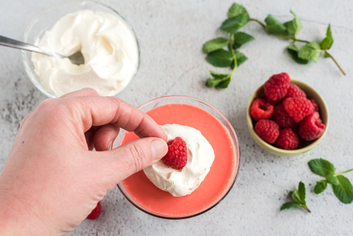 adding a raspberry on top of cool whip jello parfaits