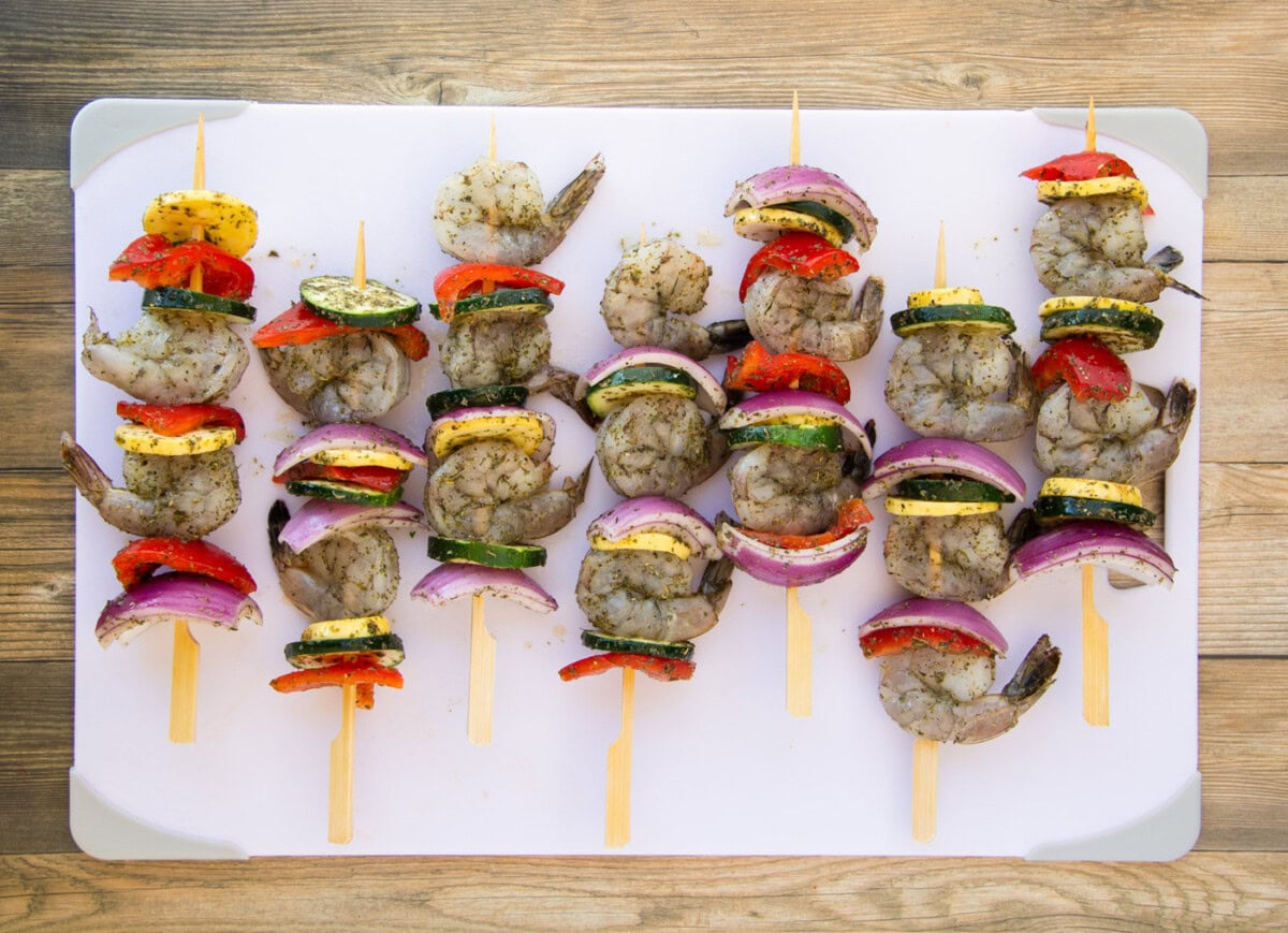 shrimp kabobs with fresh veggies on a cutting board