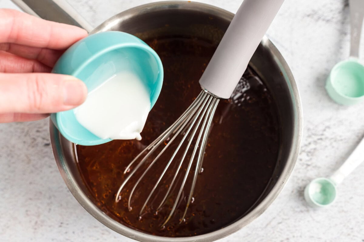 pouring cornstarch into barbecue sauce