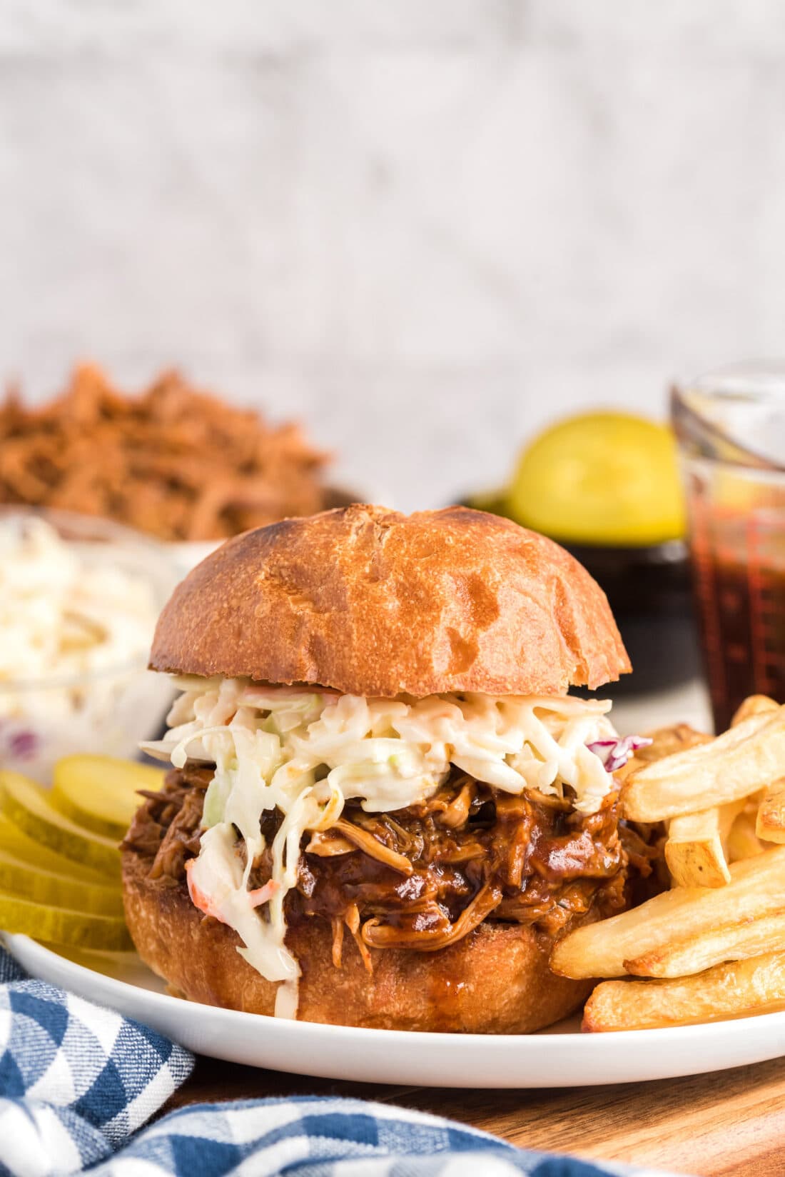 Slow Cooker Pulled Pork sandwich on plate with fries