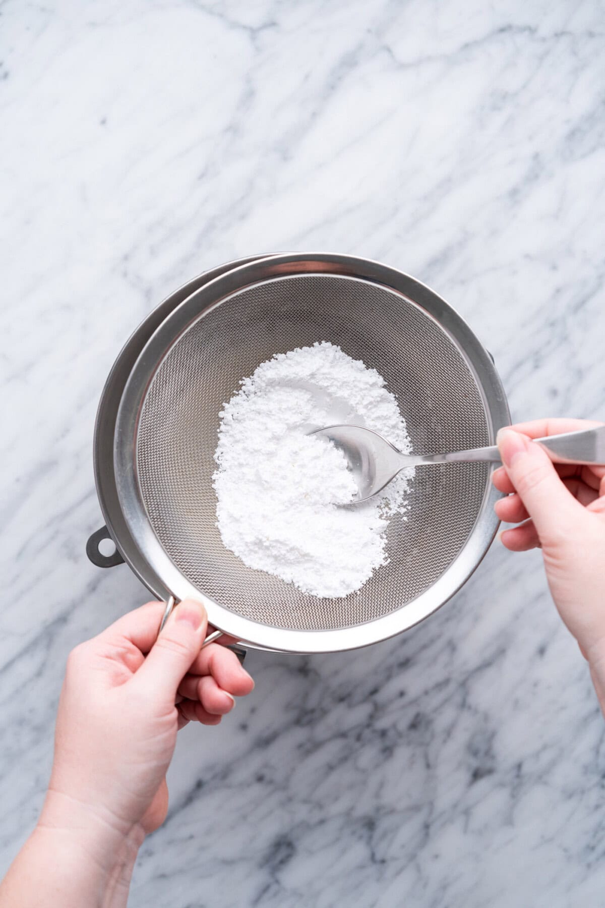 adding sifted powdered sugar to bowl