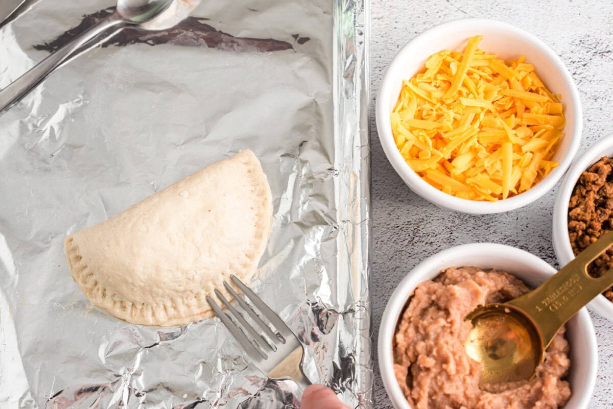 sealing empanadas with a fork