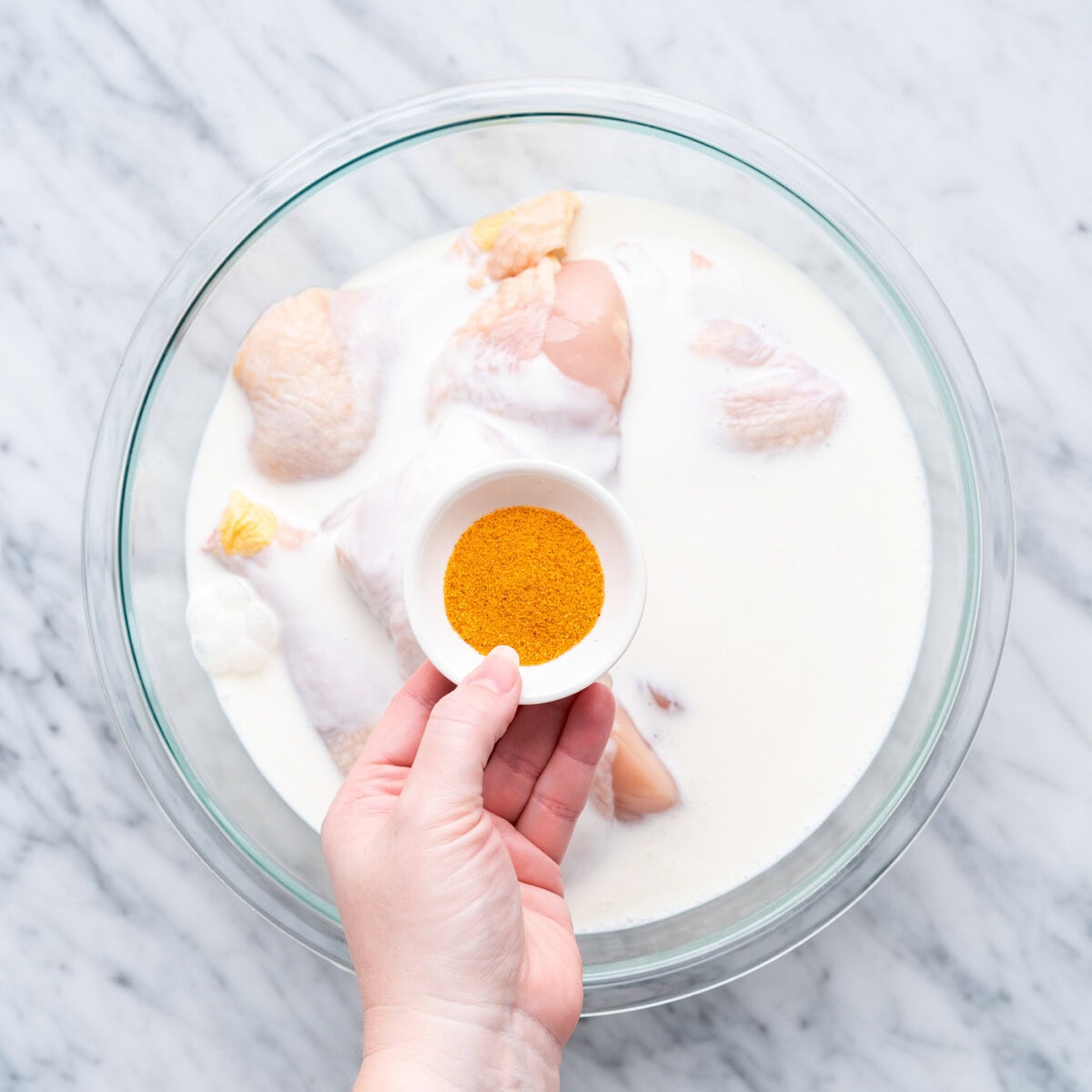 buttermilk and seasoning in a bowl of chicken