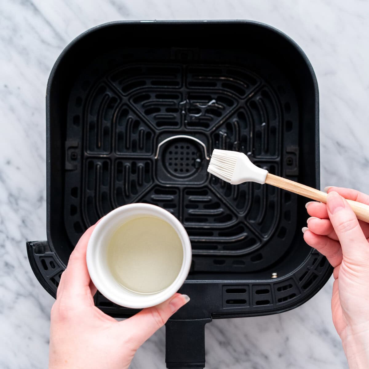 brushing air fryer with oil