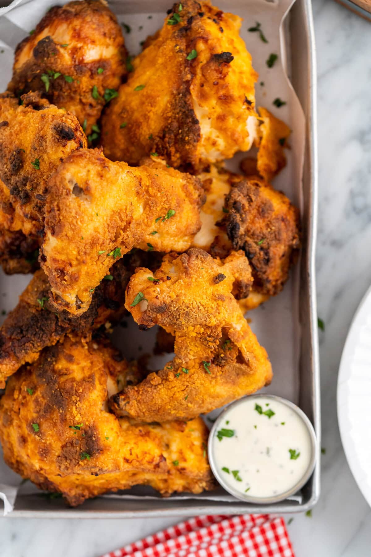 Close up photo of a tray of Air Fryer Fried Chicken with a cup of ranch on the side