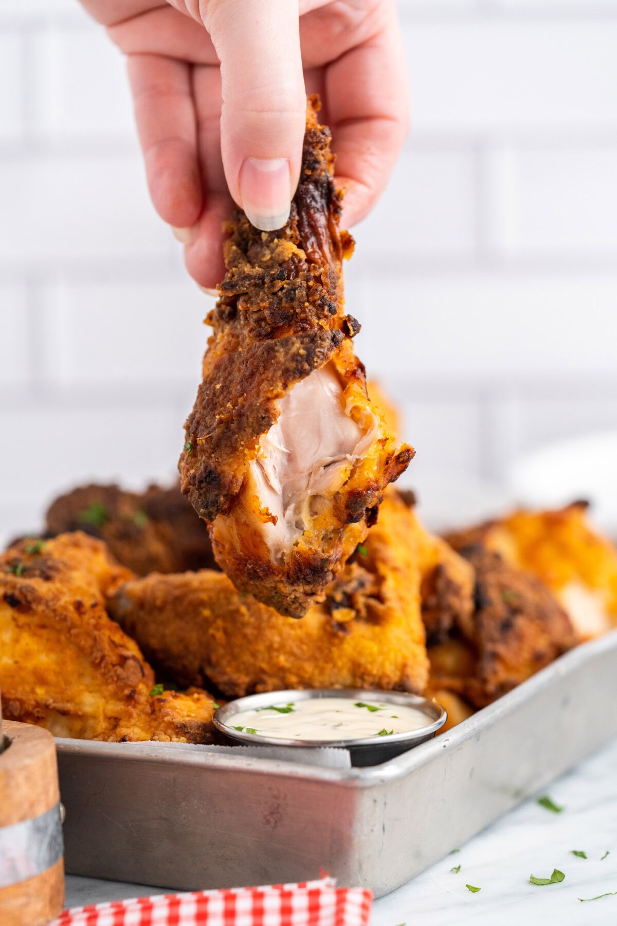 Hand holding Air Fryer Fried Chicken with a bite taken out