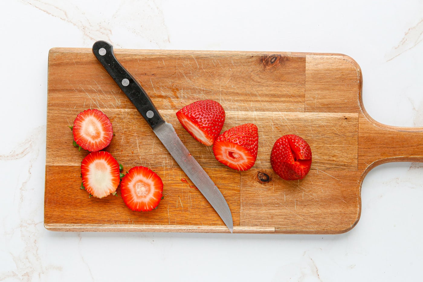 slicing the top off of strawberries