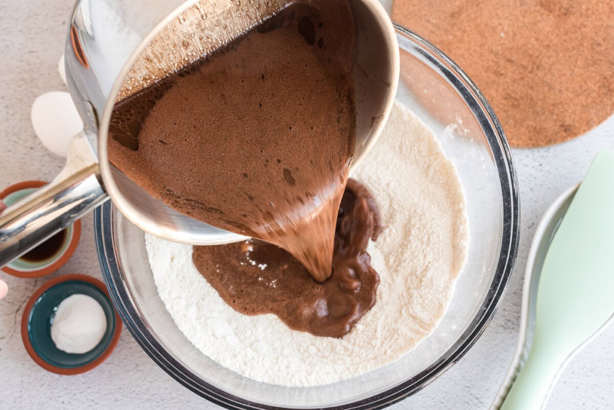 pouring chocolate batter over dry ingredients