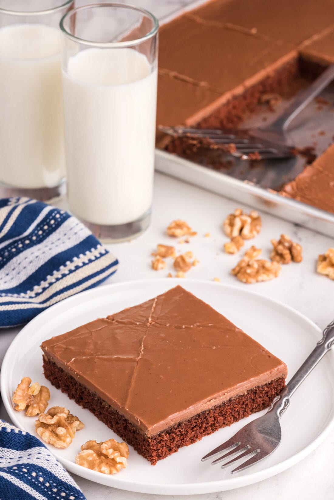 slice of Chocolate Texas Sheet Cake with glasses of milk