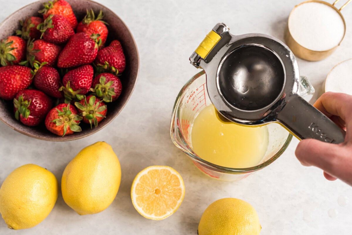 squeezing lemon juice into measuring cup