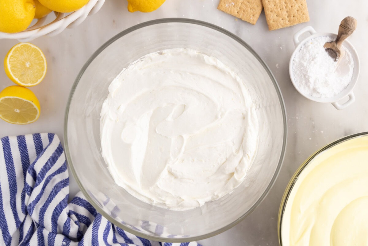 cream cheese mixture on top of graham cracker crumbs in trifle dish