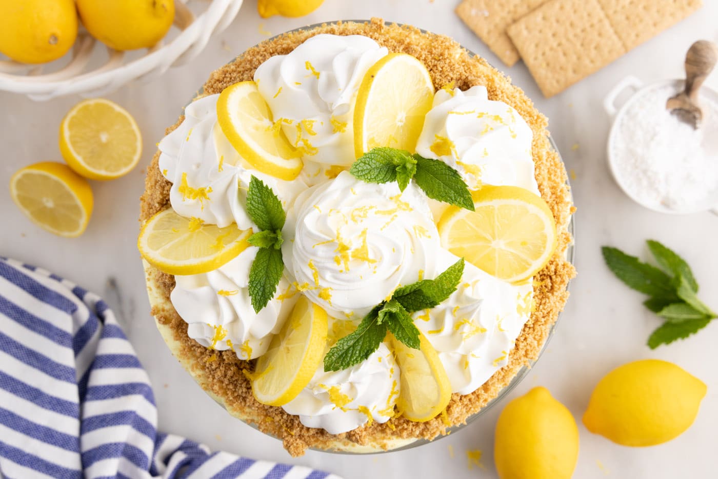 swirls of whipped cream, lemon slices, and fresh mint on top of lemon trifle