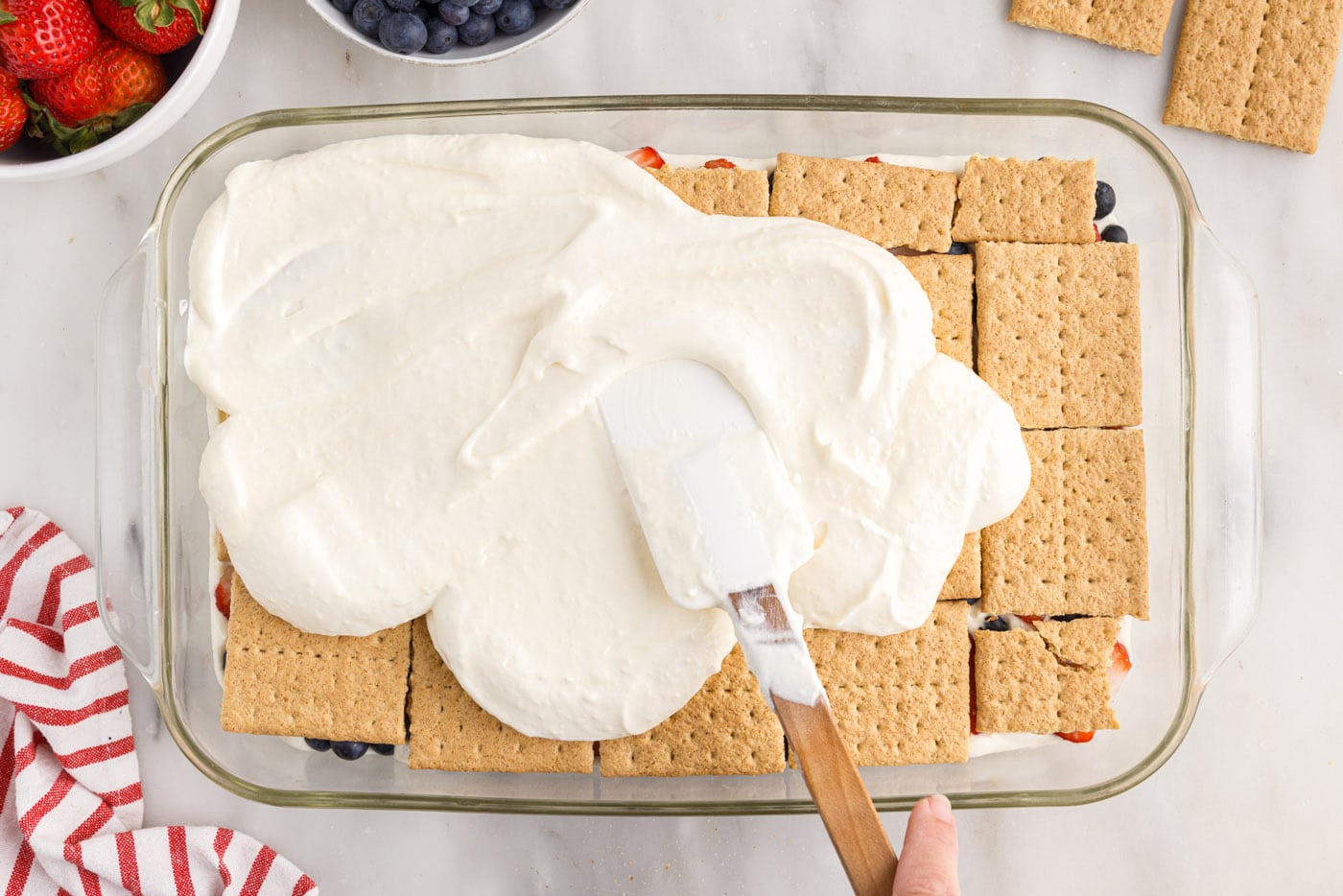 Spreading the cream cheese mixture over the graham crackers