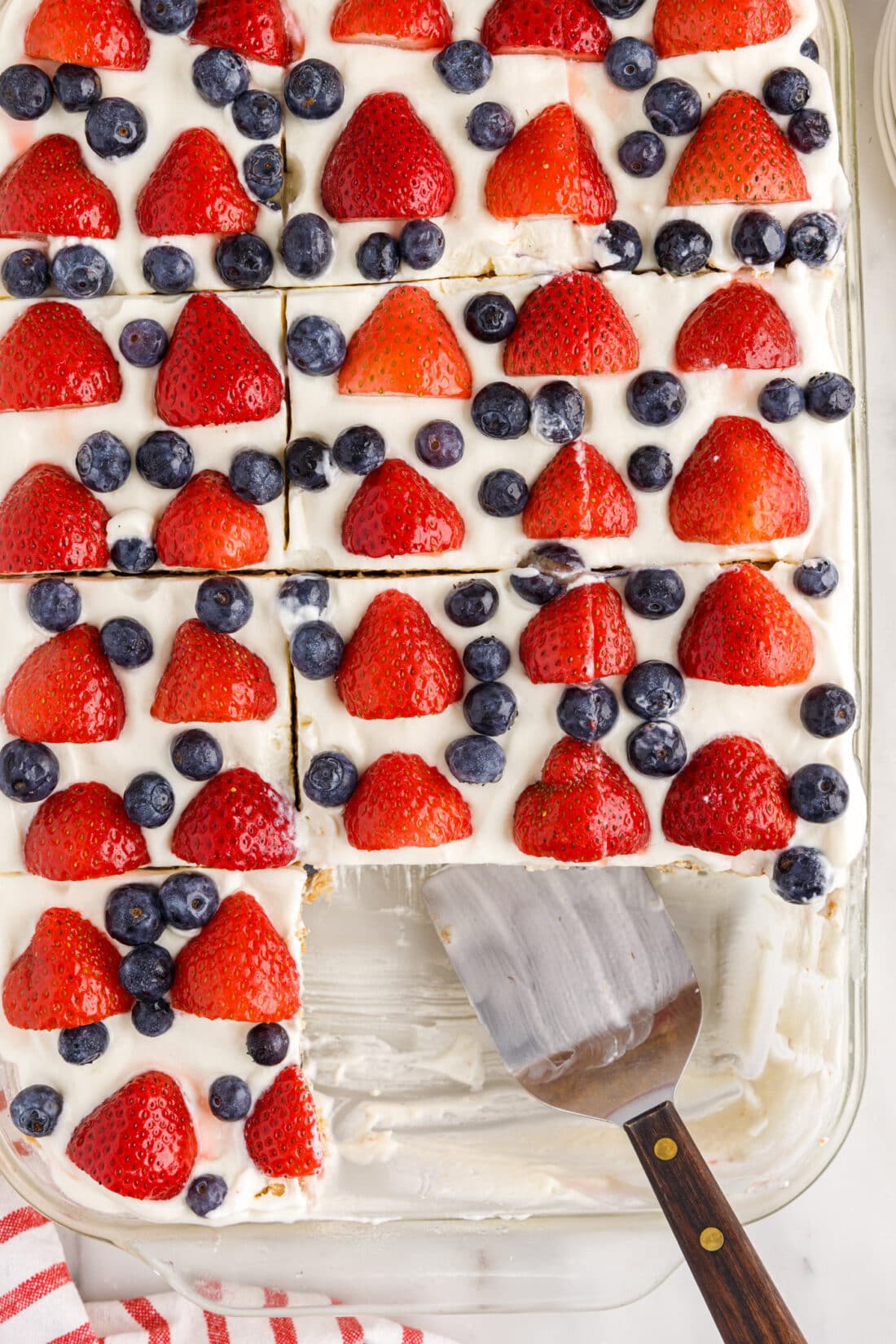 overhead of Mixed Berry Icebox Cake with slices removed and spatula in pan