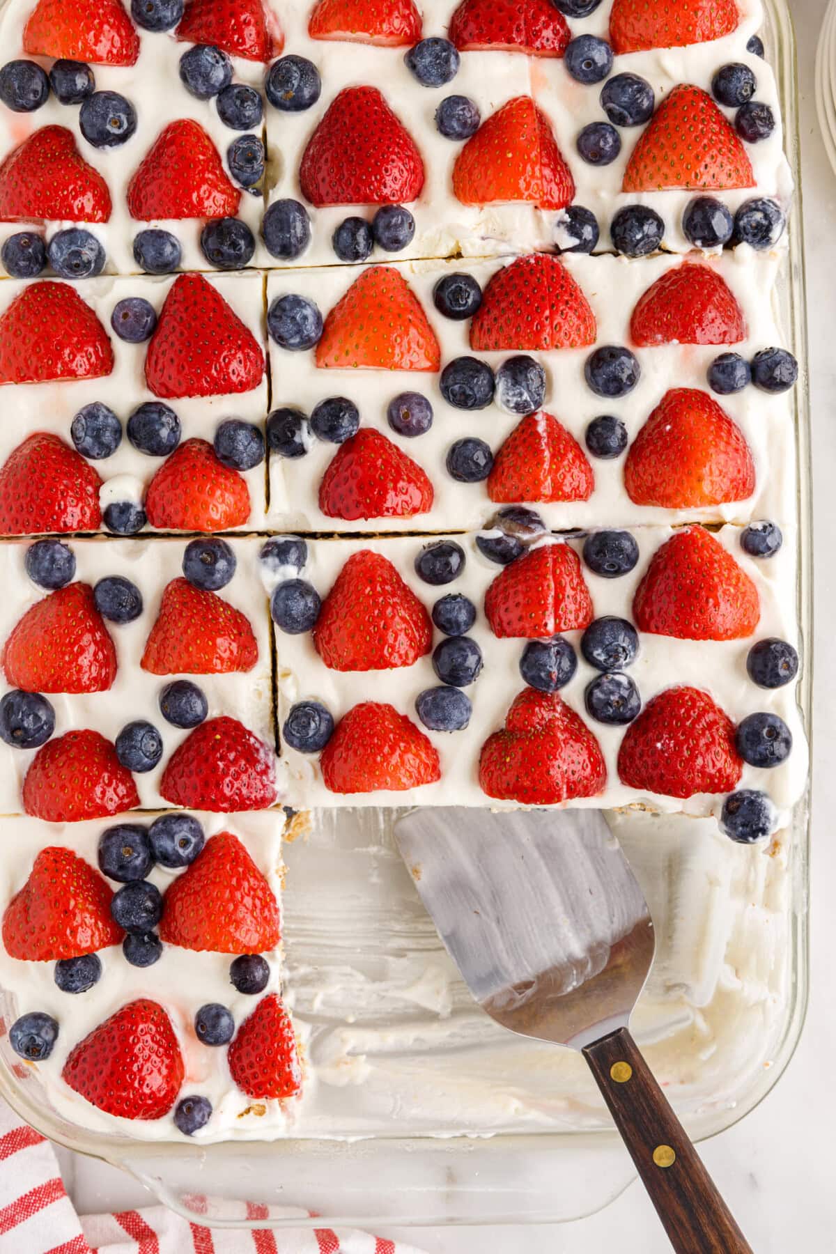 overhead of Mixed Berry Icebox Cake with slices removed and spatula in pan