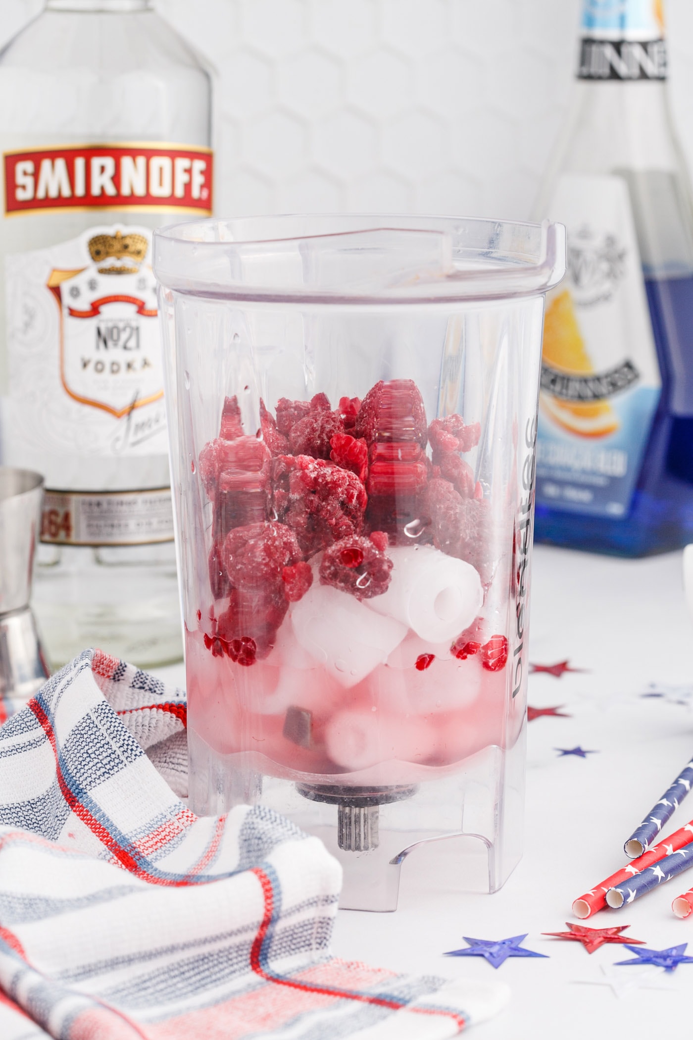 raspberry, lemonade, ice, and vodka in a blender
