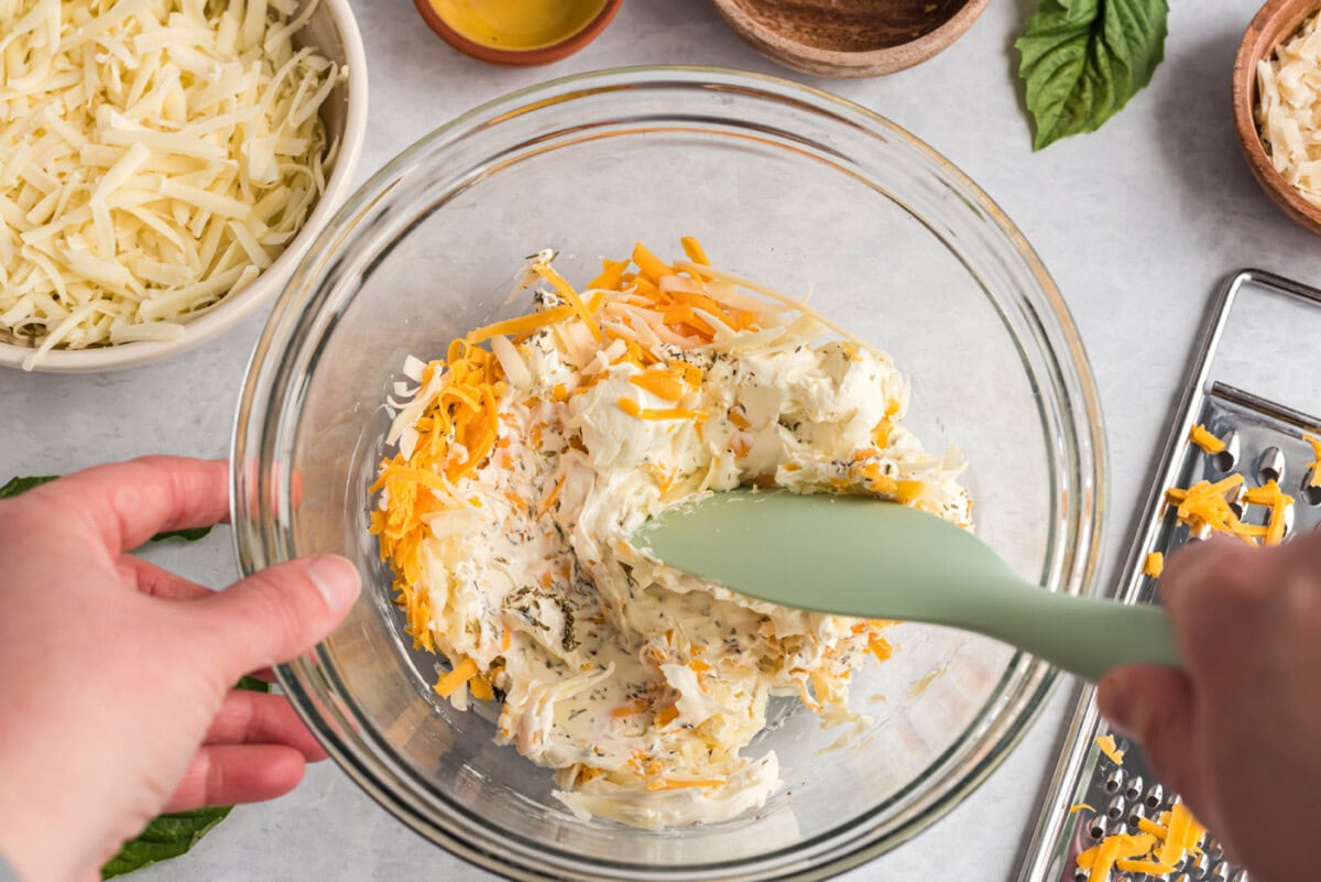mixing cheese in a bowl with seasoning