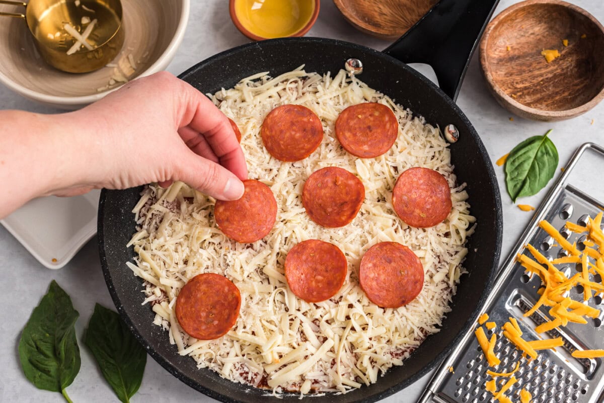 adding pepperoni to pizza dip