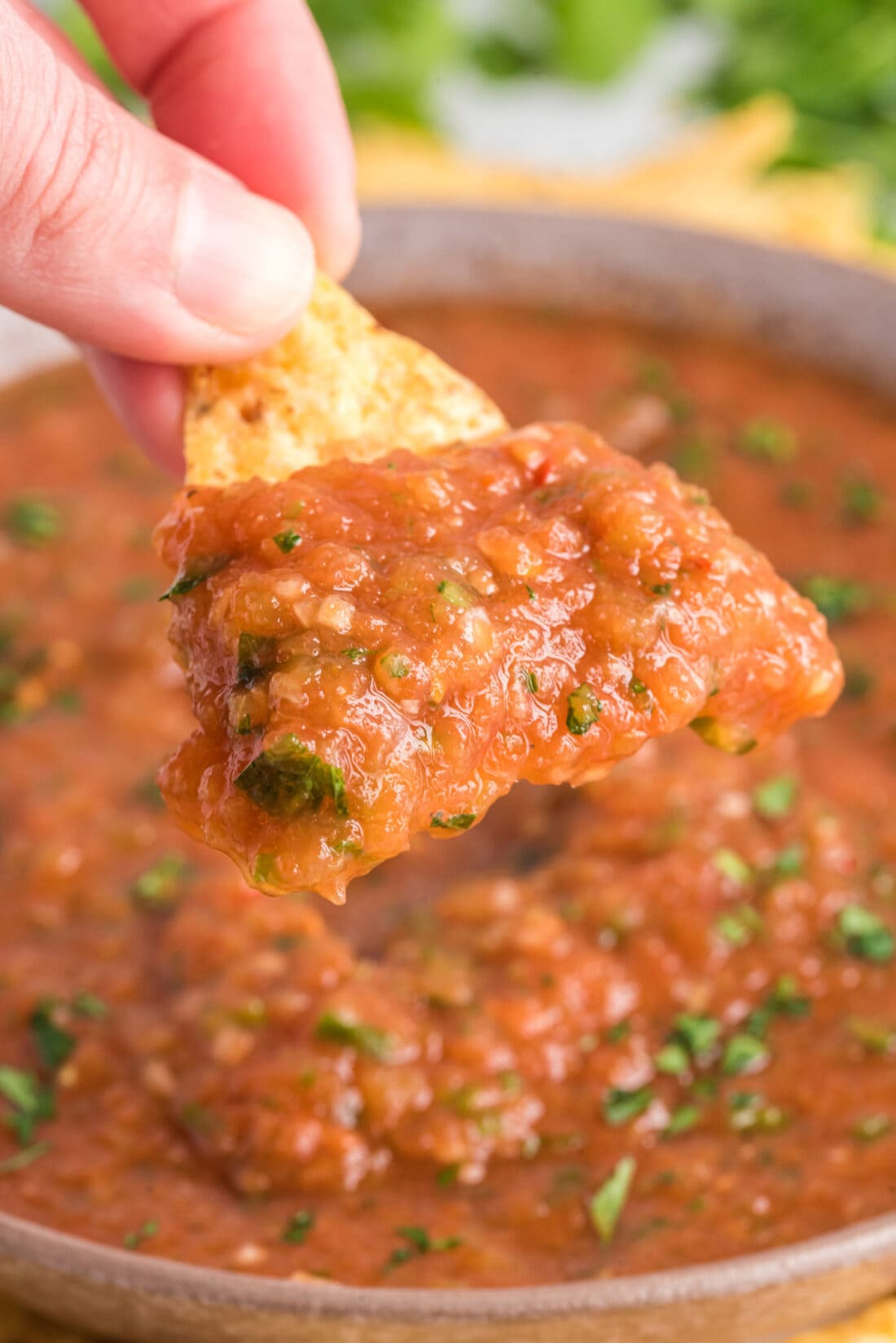dipping a tortilla chip in Restaurant Style Salsa