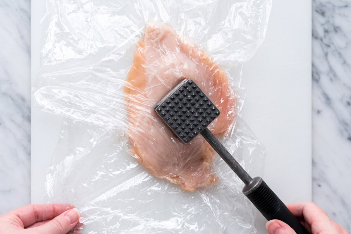 hitting chicken with a meat mallet