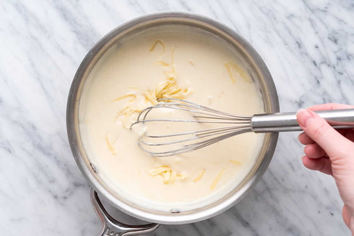whisking dijon cream sauce in a saucepan