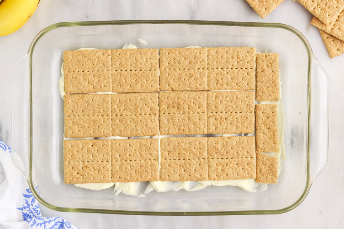 graham crackers on top of pudding mixture in a baking dish