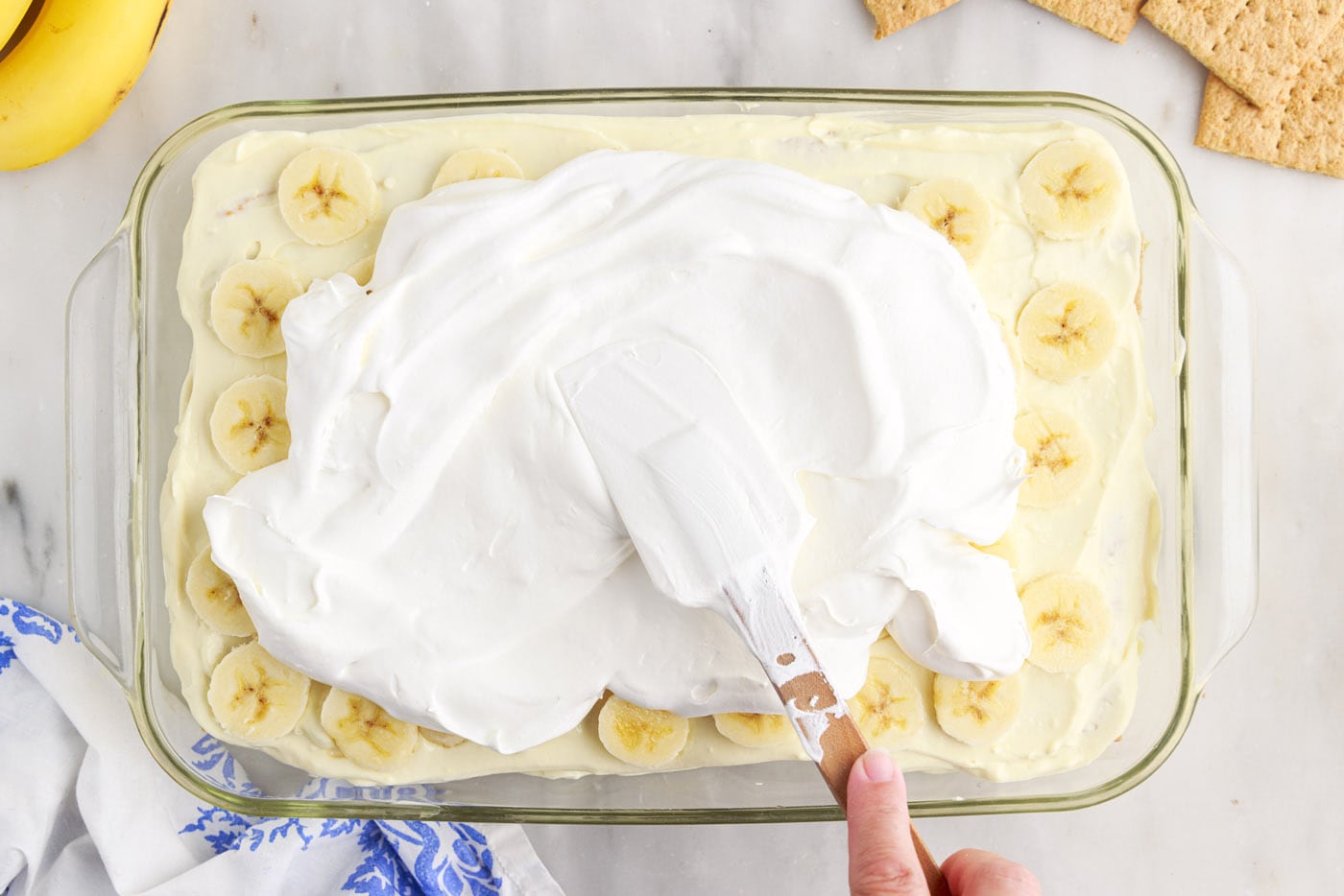 spreading cool whip over the top of banana cream pie icebox cake