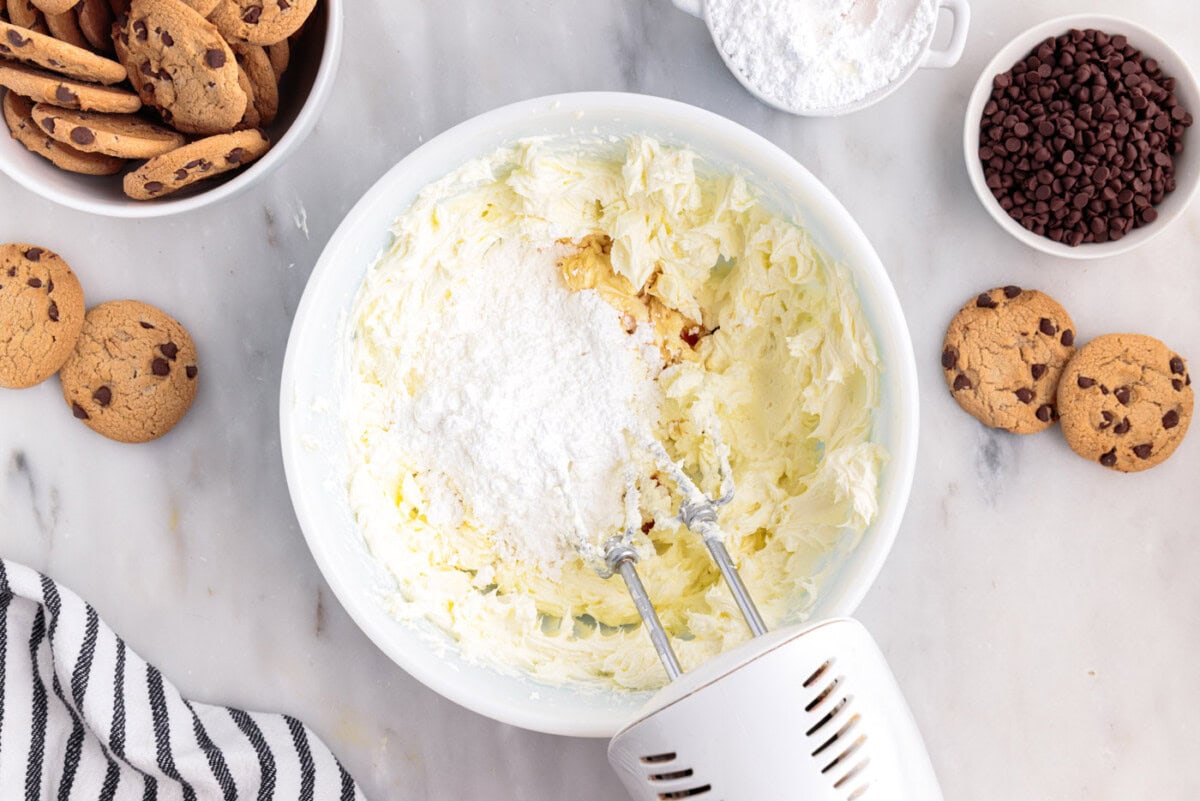 powdered sugar and vanilla added to cream cheese in a mixing bowl