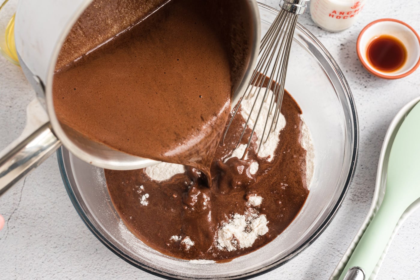 pouring chocolate mixture over flour mixture 